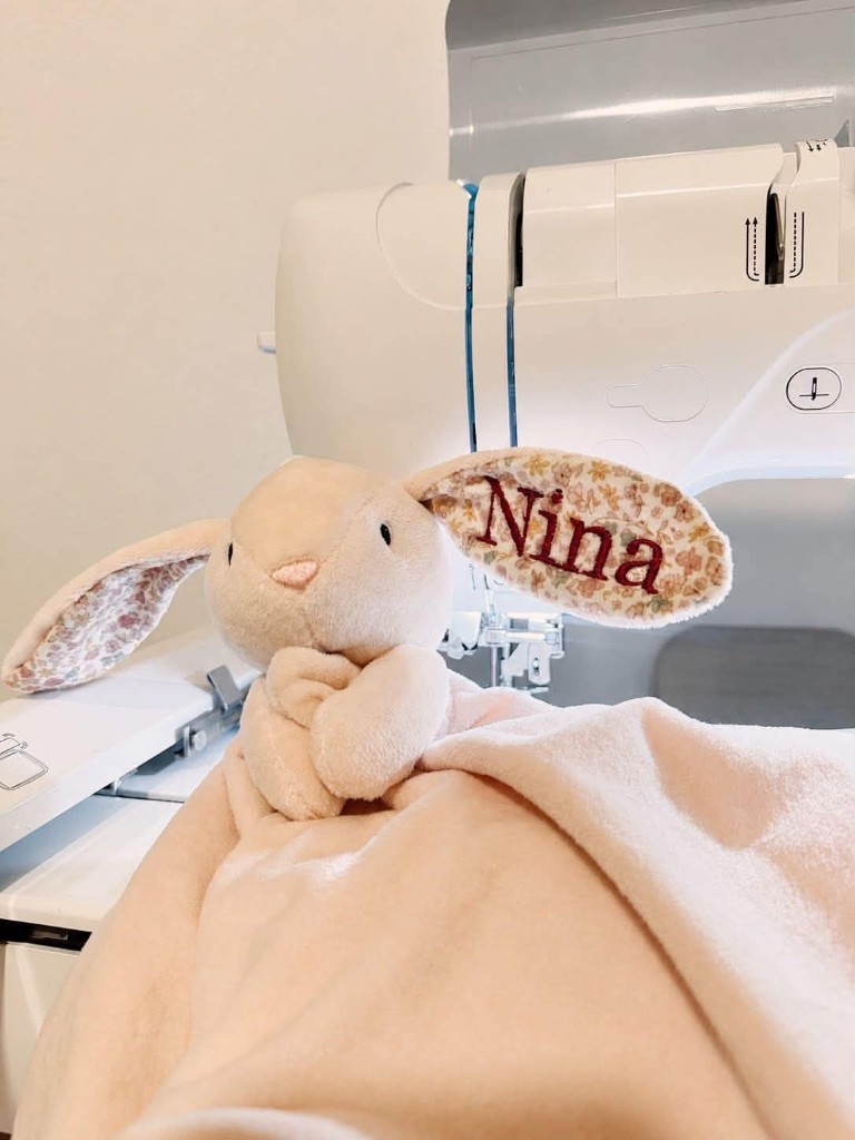 Peach bunny lovey with the name Nina embroidered on the ear