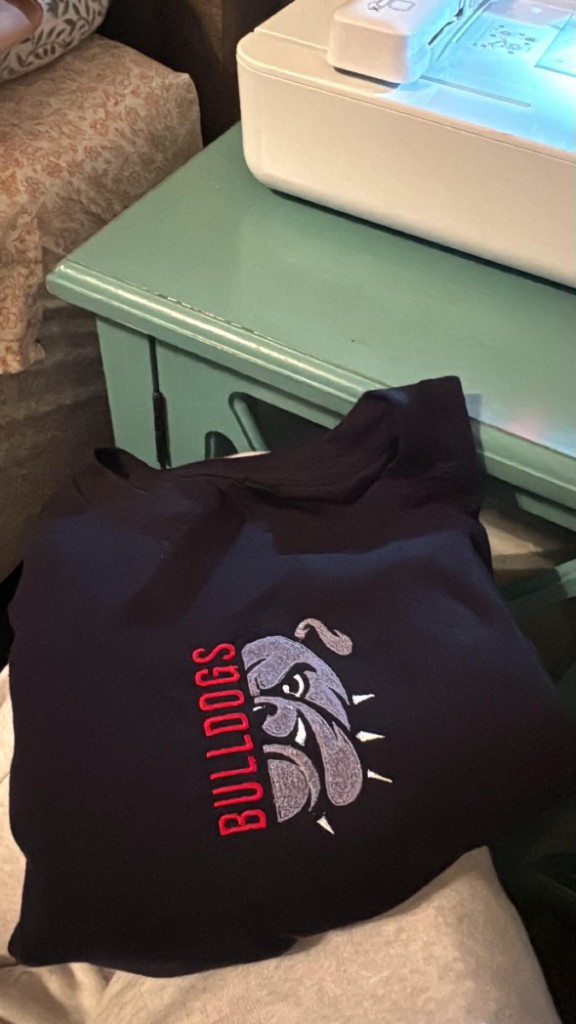 Black sweatshirt with grey bulldog head embroidery and red BULLDOGS lettering