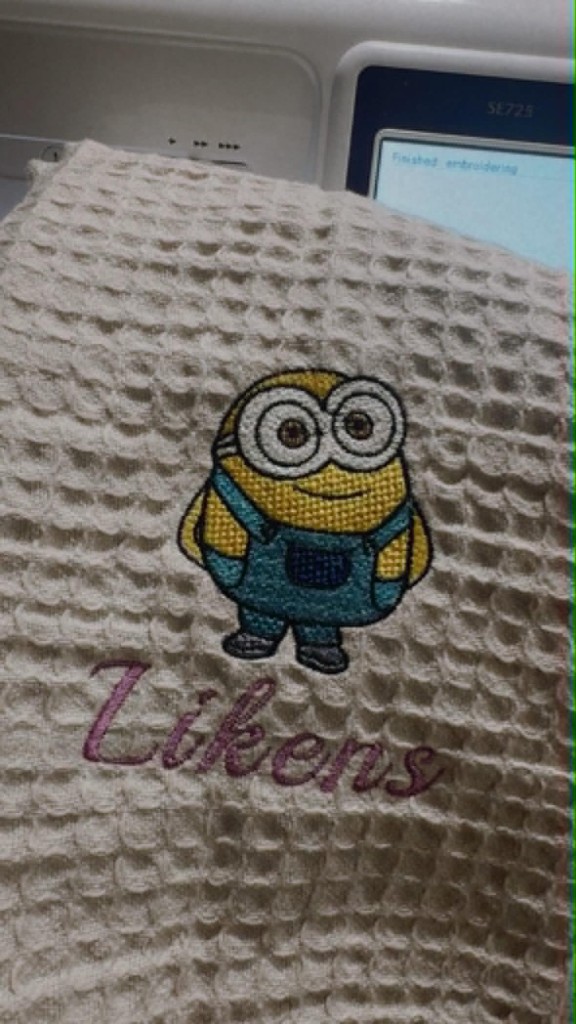 Beige waffle towel with embroidered Minion character and the name Likens